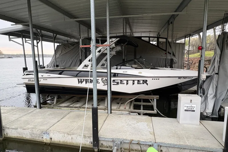 Slide: The Image of 2011 Malibu Wakesetter 247 LSV boat docked under a covered slip. - 3