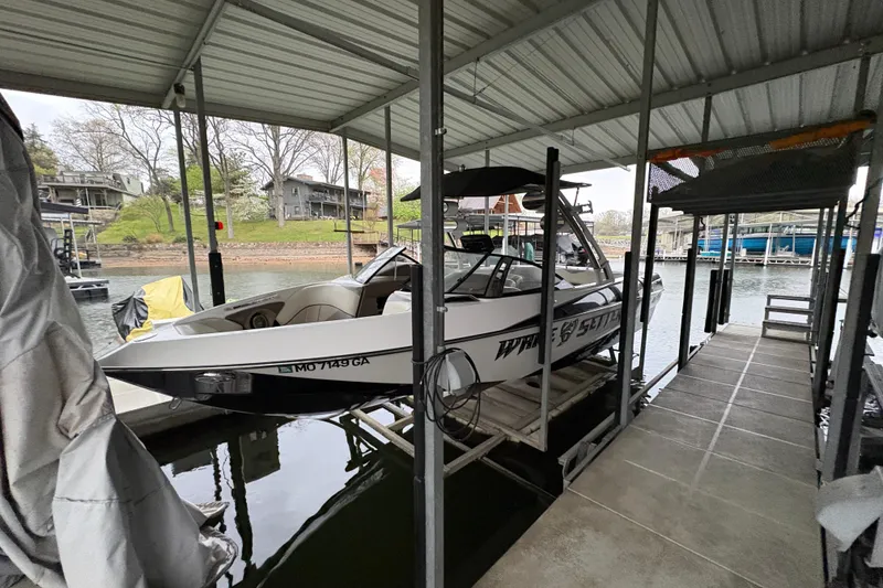 Slide: The Image of 2011 Malibu Wakesetter 247 LSV boat docked under covered slip on a lake. - 33