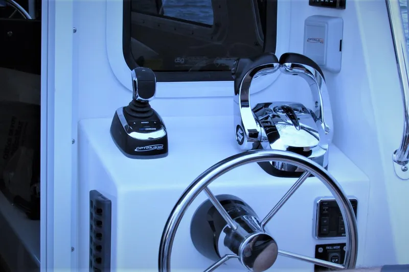 Slide: The Image of Control panel of SeaSport Kodiak 2600 boat featuring steering wheel and throttle controls. - 10