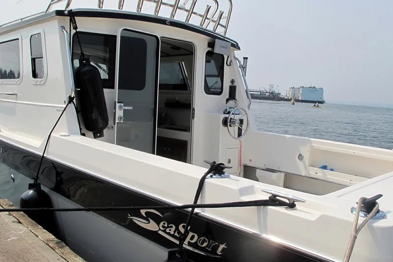 Slide: The Image of SeaSport Kodiak 2600 boat docked at a marina, featuring sleek design and spacious deck. - 5
