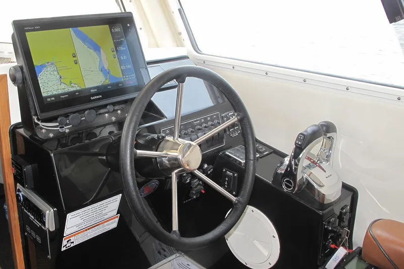 Slide: The Image of SeaSport Kodiak 2600 helm with Garmin GPS, steering wheel, and throttle controls. - 8