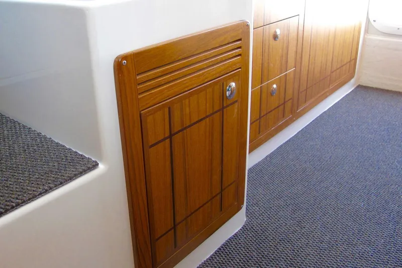 Slide: The Image of Interior of SeaSport Kodiak 2600 boat featuring wooden cabinetry and carpeted flooring. - 9