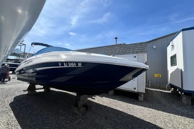 The Image of 2012 Sea Ray 220 Sundeck boat on display outdoors, blue hull, sunny day. - 0