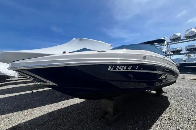 Slide: The Image of 2012 Sea Ray 220 Sundeck boat on display under a clear blue sky. - 1