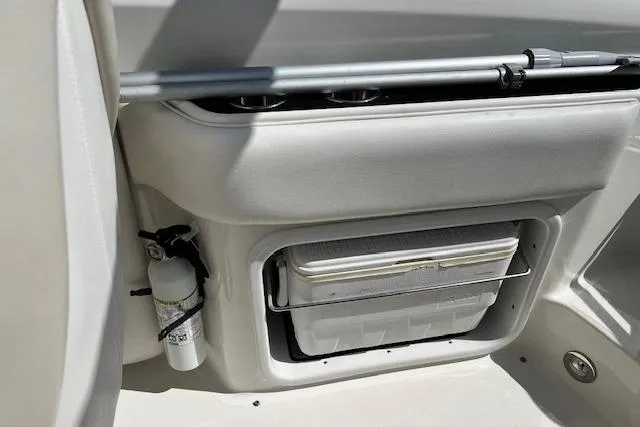 Slide: The Image of 2012 Sea Ray 220 Sundeck interior with storage compartment and fire extinguisher. - 10