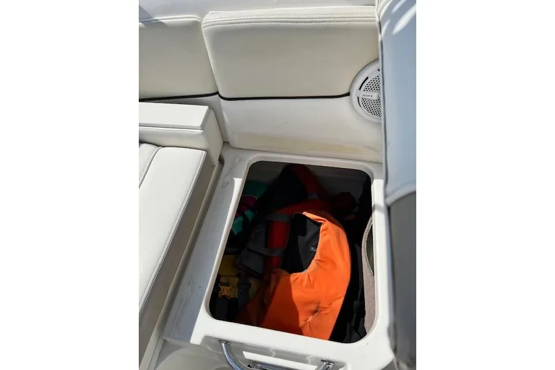 Slide: The Image of Storage compartment on a 2012 Sea Ray 220 Sundeck with life jackets inside. - 11