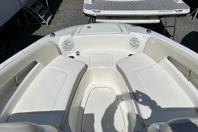 Slide: The Image of Bow seating area of a 2012 Sea Ray 220 Sundeck boat, featuring white cushioned seats. - 14