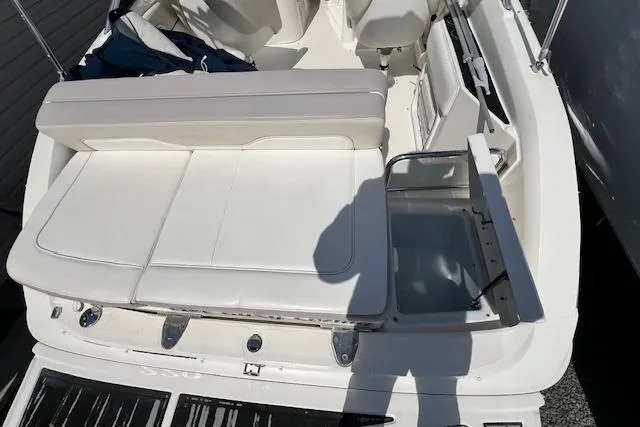 Slide: The Image of 2012 Sea Ray 220 Sundeck boat interior with white seating and storage compartment. - 19