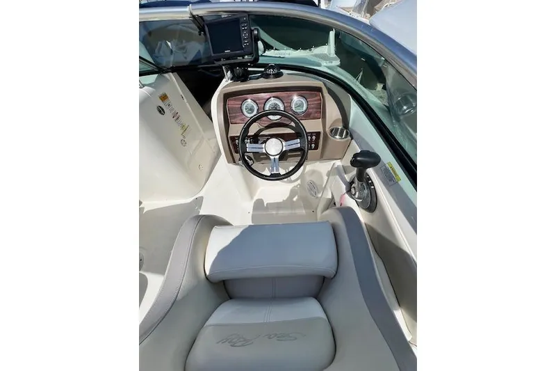 Slide: The Image of 2012 Sea Ray 220 Sundeck boat interior with steering wheel and dashboard controls. - 2