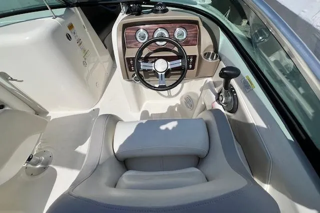 Slide: The Image of 2012 Sea Ray 220 Sundeck boat cockpit with steering wheel and dashboard controls. - 3