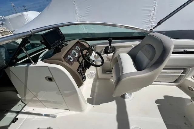 Slide: The Image of 2012 Sea Ray 220 Sundeck boat cockpit with steering wheel and control panel. - 4