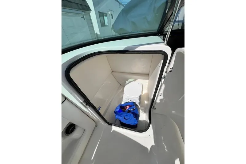 Slide: The Image of Interior of 2012 Sea Ray 220 Sundeck boat with storage compartment and blue bag. - 9