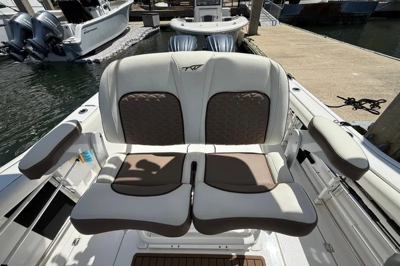 Slide: The Image of 2025 Tidewater 272 CC Adventure boat seating at dockside, featuring dual outboard engines. - 18