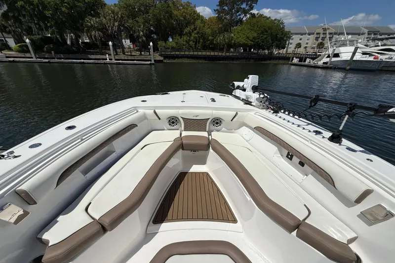 Slide: The Image of 2025 Tidewater 272 CC Adventure boat interior with cushioned seating and wood accents. - 27