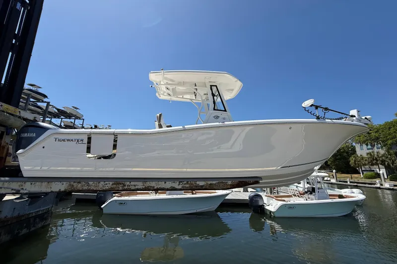 Slide: The Image of 2025 Tidewater 272 CC Adventure boat on lift, featuring sleek design and Yamaha engine. - 3