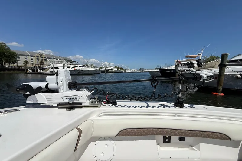 Slide: The Image of 2025 Tidewater 272 CC Adventure boat docked, featuring Minn Kota trolling motor, in a marina setting. - 30