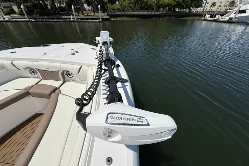 Slide: The Image of 2025 Tidewater 272 CC Adventure boat with Minn Kota trolling motor on calm water. - 31