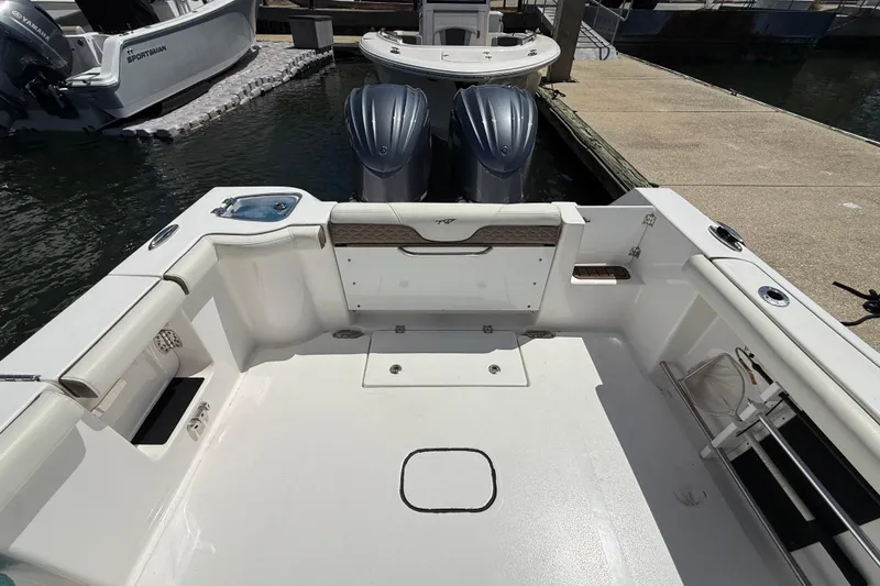 Slide: The Image of 2025 Tidewater 272 CC Adventure boat interior with dual engines at dock. - 34