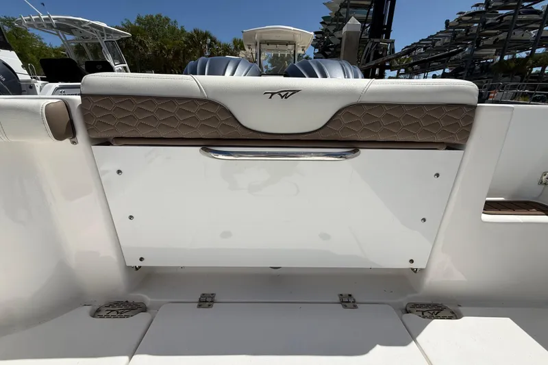 Slide: The Image of 2025 Tidewater 272 CC Adventure boat interior with cushioned seating and storage compartment. - 35