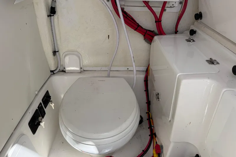 Slide: The Image of 2025 Tidewater 272 CC Adventure boat interior with marine toilet and wiring. - 37