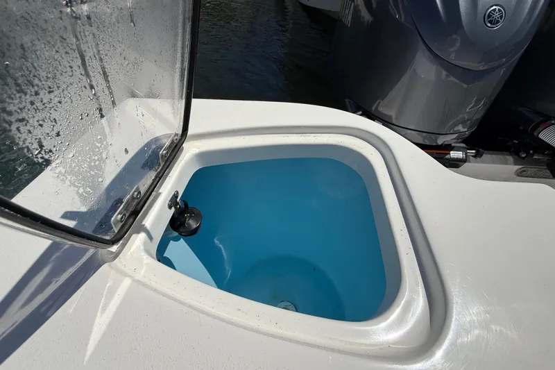 Slide: The Image of Livewell on 2025 Tidewater 272 CC Adventure boat, open lid, blue interior. - 38