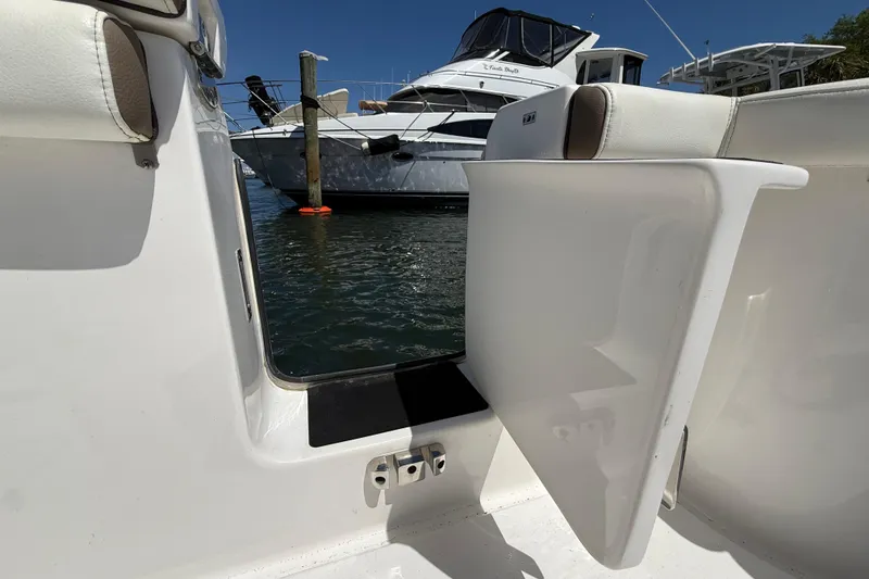 Slide: The Image of 2025 Tidewater 272 CC Adventure boat with open side door, docked near another vessel. - 42