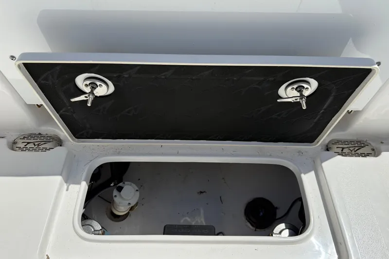 Slide: The Image of 2025 Tidewater 272 CC Adventure boat storage compartment with secure latches and visible interior components. - 43