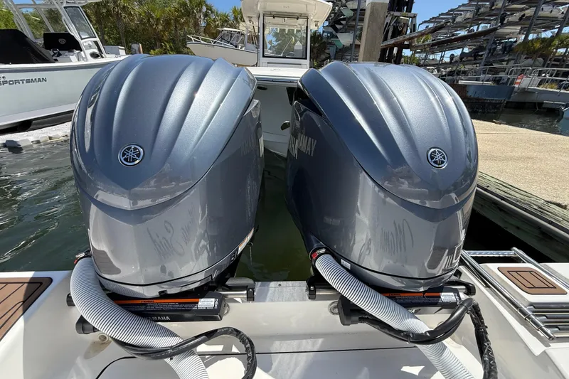 Slide: The Image of Twin Yamaha outboard engines on a 2025 Tidewater 272 CC Adventure boat at a marina. - 44
