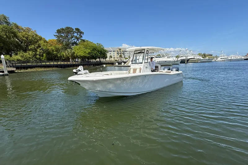 Slide: The Image of 2025 Tidewater 272 CC Adventure boat cruising on a sunny day in a marina. - 7