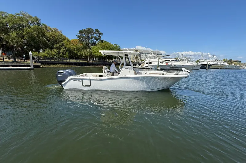 Slide: The Image of 2025 Tidewater 272 CC Adventure boat cruising on a sunny day in a marina. - 8