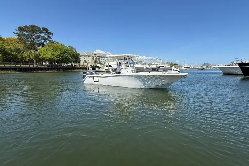 Slide: The Image of 2025 Tidewater 272 CC Adventure boat cruising on a sunny day in a marina. - 9
