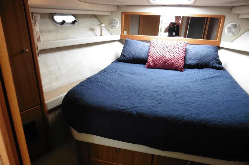 Slide: The Image of Cozy bedroom in 2000 Bayliner 3988 Command Bridge Motoryacht with blue bedding and red pillow. - 15