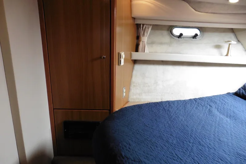 Slide: The Image of Interior cabin of 2000 Bayliner 3988 Command Bridge Motoryacht with blue bedding and wooden cabinetry. - 19