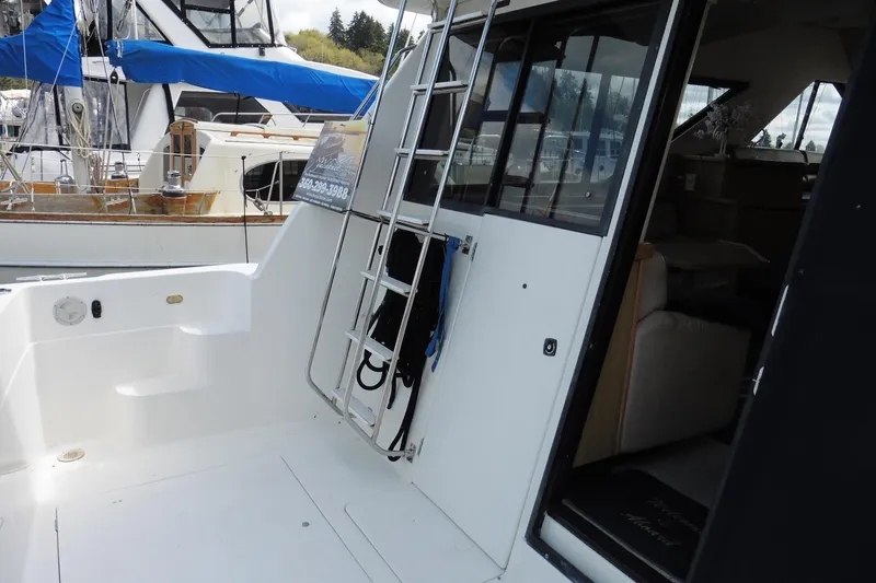 Slide: The Image of 2000 Bayliner 3988 Command Bridge Motoryacht, exterior view with ladder and open cabin door. - 3