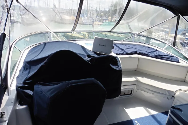 Slide: The Image of 2000 Bayliner 3988 Command Bridge Motoryacht interior with covered seating and Garmin navigation. - 32