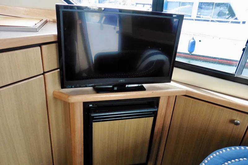 Slide: The Image of TV and mini-fridge in 2000 Bayliner 3988 Command Bridge Motoryacht interior. - 38