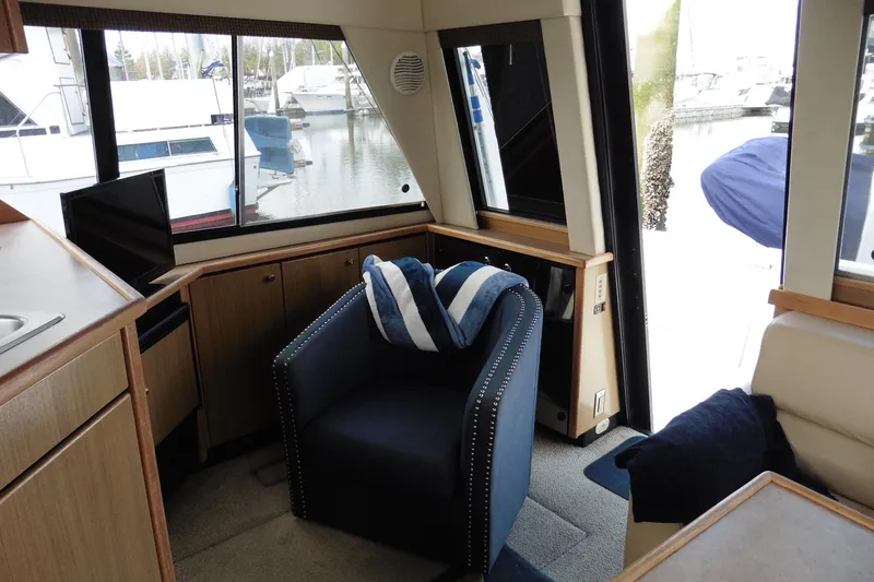Slide: The Image of Interior of 2000 Bayliner 3988 Command Bridge Motoryacht with cozy seating and marina view. - 6