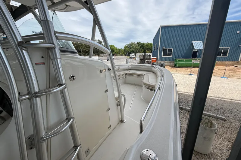 Slide: The Image of 2004 Boston Whaler 320 Outrage boat with stainless steel railings, docked near a blue building. - 10