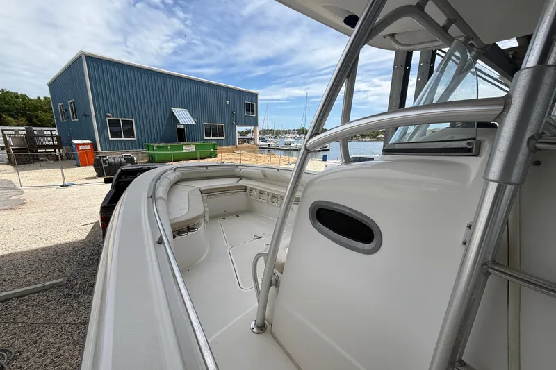 Slide: The Image of 2004 Boston Whaler 320 Outrage boat docked near a blue building and marina. - 11