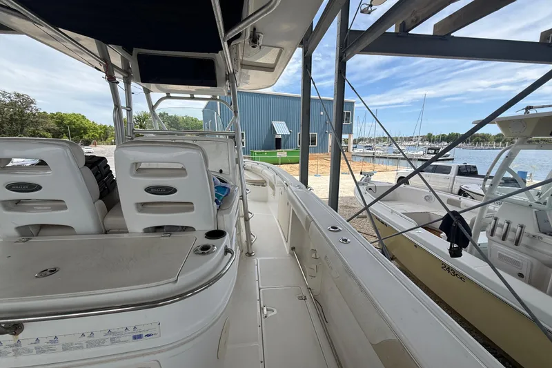 Slide: The Image of 2004 Boston Whaler 320 Outrage boat docked at marina, showcasing interior seating and console. - 13