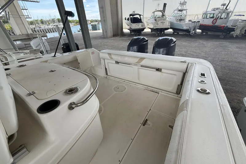 Slide: The Image of 2004 Boston Whaler 320 Outrage boat interior with dual engines in a marina setting. - 20