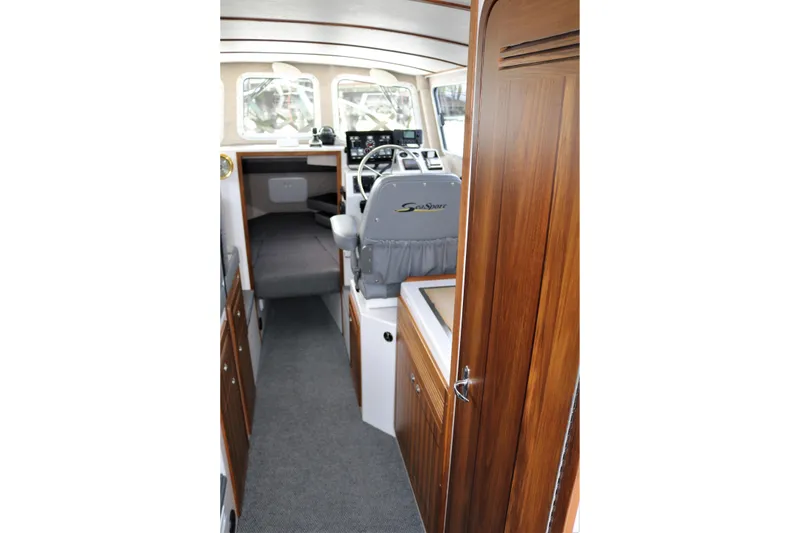 Slide: The Image of Interior of 2026 SeaSport Aleutian 2600 boat with wood paneling and helm station. - 14
