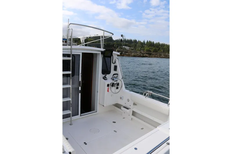 Slide: The Image of 2026 SeaSport Aleutian 2600 boat deck with steering wheel, ladder, and ocean view. - 19