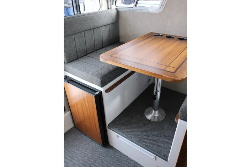 Slide: The Image of Interior of 2026 SeaSport Aleutian 2600 with wooden table and cushioned seating. - 24