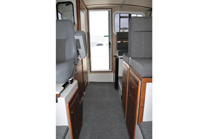 Slide: The Image of Interior of 2026 SeaSport Aleutian 2600 boat, featuring gray seating and wooden cabinetry. - 27