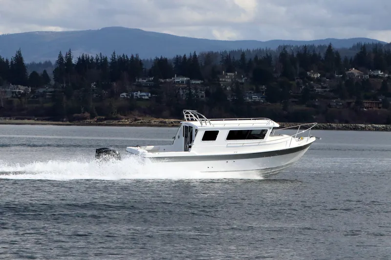 Slide: The Image of 2026 SeaSport Aleutian 2600 cruising on a scenic lake with forested hills in the background. - 4