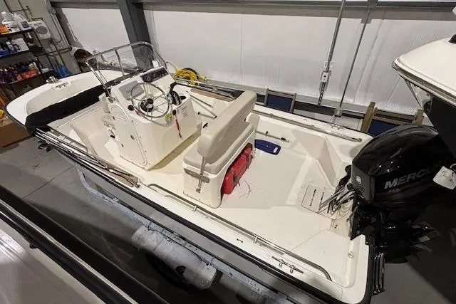 Slide: The Image of 2018 Boston Whaler 150 Montauk boat in storage, featuring a Mercury outboard motor. - 12