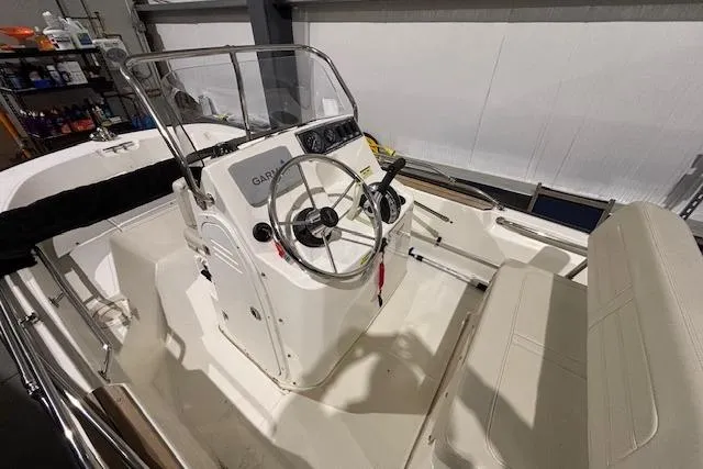 Slide: The Image of 2018 Boston Whaler 150 Montauk boat interior with steering wheel and seating. - 4