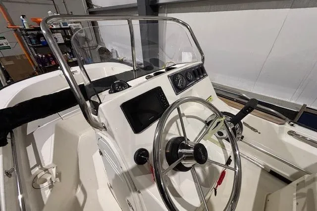 Slide: The Image of 2018 Boston Whaler 150 Montauk boat console with steering wheel and controls. - 6