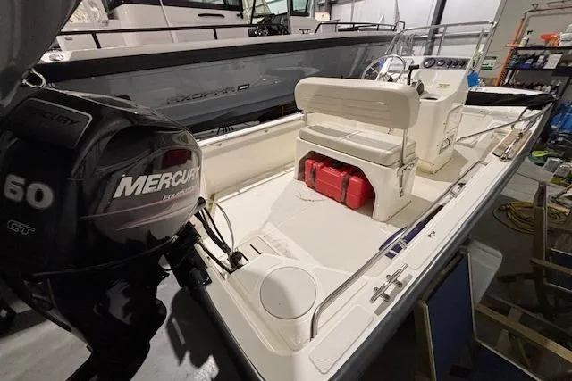 Slide: The Image of 2018 Boston Whaler 150 Montauk boat with Mercury engine in a garage. - 7